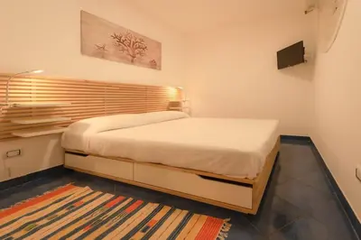a bedroom with a bed and a rug at Design loft Marinella in Porticello in Santa Flavia