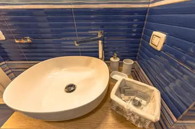 a white sink in a bathroom with blue walls at Design loft Marinella in Porticello in Santa Flavia
