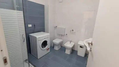 a bathroom with a washing machine and a toilet at casa francesca 2 LOFTY in Castellammare del Golfo