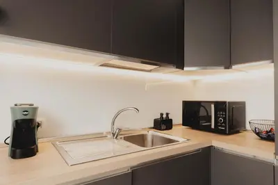 a kitchen with a sink and a microwave at Villa Levante, relax esclusivo a due passi dal mare vicino Cefalù in Lascari