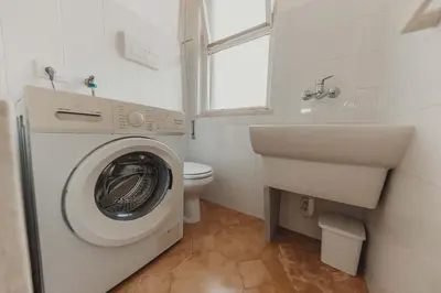a bathroom with a washing machine and a toilet at Villa Levante, relax esclusivo a due passi dal mare vicino Cefalù in Lascari