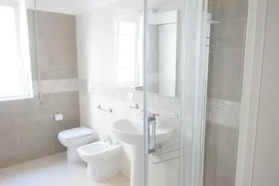 a bathroom with a sink and a toilet and a mirror at Villabianca Vacanze in Palermo