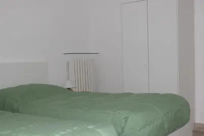 two green beds in a white bedroom with a lamp at Villabianca Vacanze in Palermo