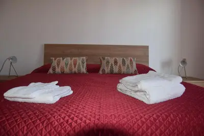 a red bed with white towels on top of it at Villabianca Vacanze in Palermo