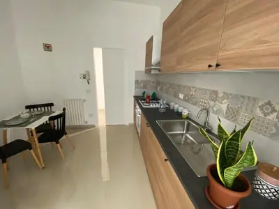a kitchen with a sink and a dining table at Villabianca Vacanze in Palermo