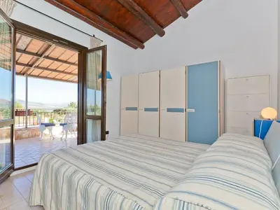 a bedroom with a large bed and a balcony at Villa Tenute Aversa by Interhome in Castellammare del Golfo