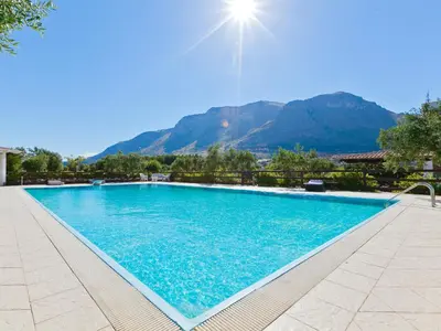 a large swimming pool with mountains in the background at Villa Tenute Aversa by Interhome in Castellammare del Golfo