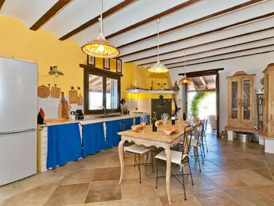 a large kitchen with a wooden table and blue cabinets at Villa Tenute Aversa by Interhome in Castellammare del Golfo