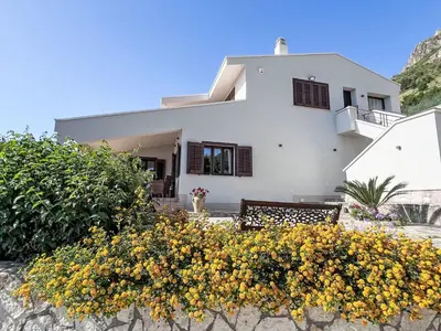 a white house with yellow flowers in front of it at Apartment Bouganville di Patrizia by Interhome in Castellammare del Golfo