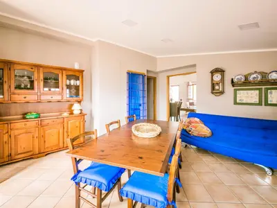 a dining room with a blue couch and a table at Apartment Bouganville di Patrizia by Interhome in Castellammare del Golfo