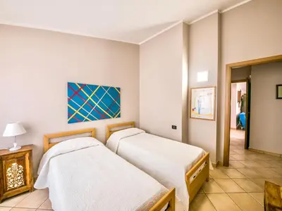 a bedroom with two beds and a painting on the wall at Apartment Bouganville di Patrizia by Interhome in Castellammare del Golfo