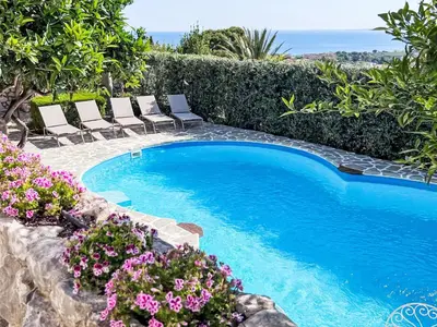 a swimming pool with lounge chairs and flowers at Apartment Bouganville di Patrizia by Interhome in Castellammare del Golfo