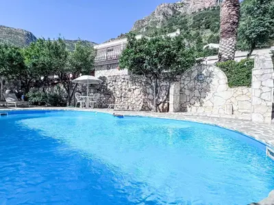 a large blue swimming pool in front of a building at Apartment Bouganville di Patrizia by Interhome in Castellammare del Golfo