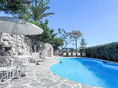 a swimming pool with chairs and an umbrella at Holiday Home Melograno di Patrizia by Interhome in Castellammare del Golfo
