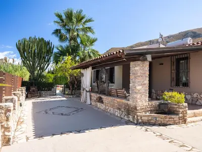 a house with a patio and a palm tree at Villa Nicole con Dependance by Interhome in Castellammare del Golfo