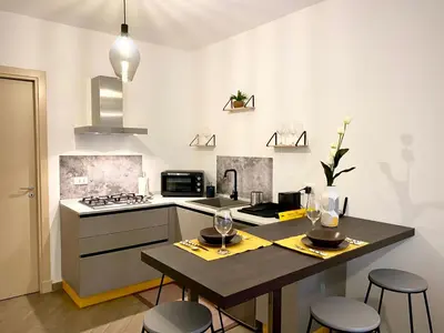 a kitchen with a table with two wine glasses on it at Quattro Canti al Cassaro in Palermo