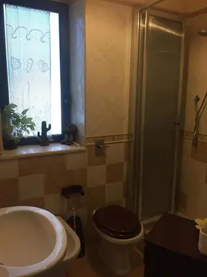 a bathroom with a sink and a toilet and a window at mondello lilla' room in Palermo