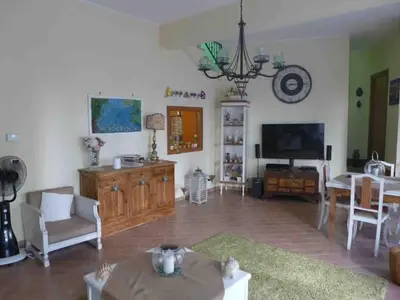a living room with a television and a dining room at mondello lilla' room in Palermo