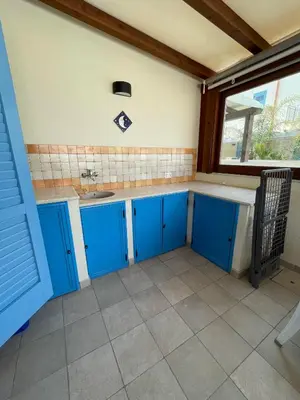 a kitchen with blue cabinets and a sink at NEREA - Appartamento fronte mare in San Vito lo Capo