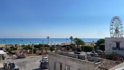 a ferris wheel in a city with a beach at NEREA - Appartamento fronte mare in San Vito lo Capo