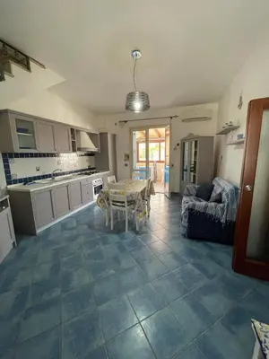 a kitchen and living room with a couch and a table at NEREA - Appartamento fronte mare in San Vito lo Capo