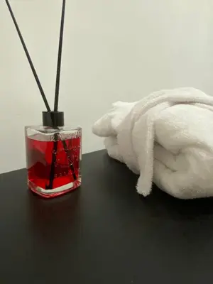 a glass container with red liquid next to a white towel at Patio1861 - A Sicilian deluxe apartment in Termini Imerese
