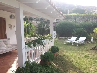 a porch with two white chairs and a fence at NUOVA Villa Intera Guidaloca in Scopello