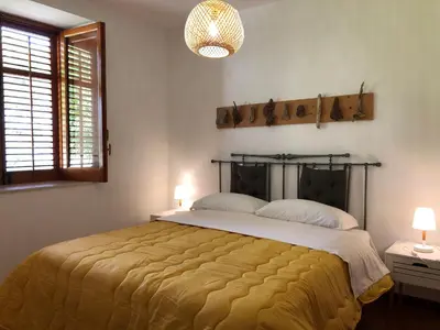 a bedroom with a large bed with a yellow blanket at TORRE MARIZA Guidaloca in Scopello