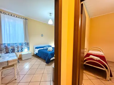 a bedroom with a bed and a table and a window at Le Maioliche in Sferracavallo