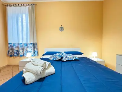 a blue bed with towels on it in a bedroom at Le Maioliche in Sferracavallo