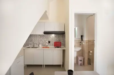 a small kitchen with a sink and a red chair at Isola bella in Isola delle Femmine