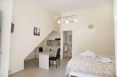 a bedroom with a bed and a table and a kitchen at Isola bella in Isola delle Femmine