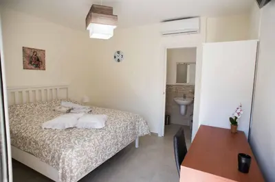 a bedroom with a bed and a bathroom with a sink at Isola bella in Isola delle Femmine