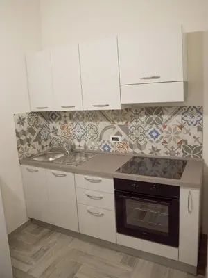 a kitchen with white cabinets and a sink and a stove at I TRAMONTI D'ASPRA in Bagheria