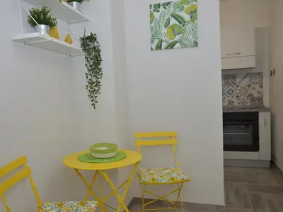 a kitchen with a yellow table and two chairs at I TRAMONTI D'ASPRA in Bagheria