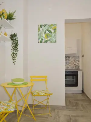 a kitchen with a table and two chairs and a table at I TRAMONTI D'ASPRA in Bagheria