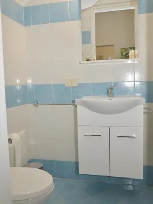a bathroom with a white sink and a toilet at I TRAMONTI D'ASPRA in Bagheria