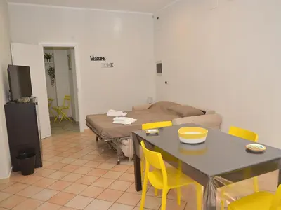 a living room with a table and yellow chairs at I TRAMONTI D'ASPRA in Bagheria