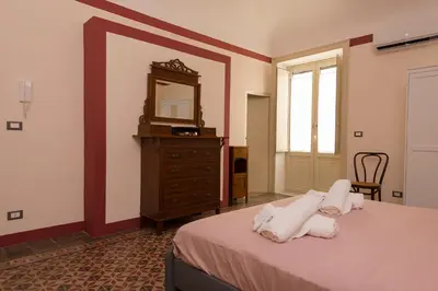 a bedroom with a bed and a dresser and a mirror at La casetta di Maria alla Ciba in Termini Imerese