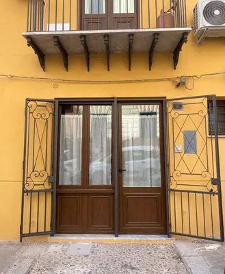 a building with a wooden door and windows at La casetta di Maria alla Ciba in Termini Imerese