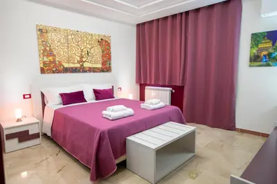 a bedroom with a pink bed with a purple blanket at B&B Azul in Palermo
