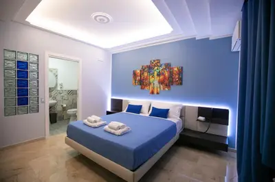 a bedroom with a bed with a painting on the wall at B&B Azul in Palermo