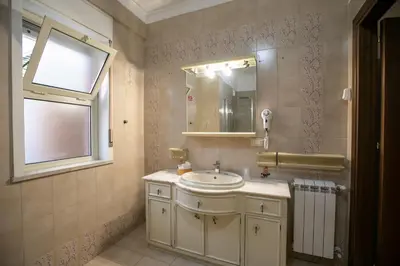 a bathroom with a sink and a mirror and a window at B&B Azul in Palermo