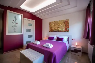 a bedroom with a purple bed with two towels on it at B&B Azul in Palermo