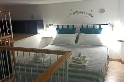 a bedroom with a large bed with a blue headboard at Le notti di Nettuno a Isola Delle Femmine in Isola delle Femmine