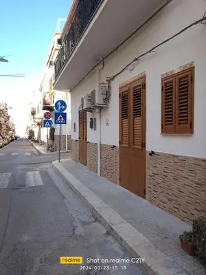 a building with wooden doors on the side of a street at Le notti di Nettuno a Isola Delle Femmine in Isola delle Femmine