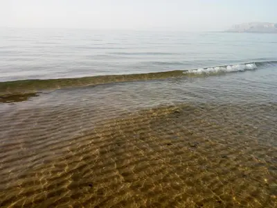 a beach with a small wave in the water at Residenza sabbia dorata in Alcamo