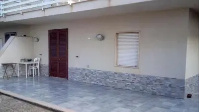 a patio of a house with a table and a window at Residenza sabbia dorata in Alcamo