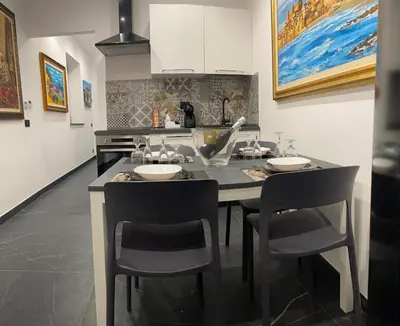 a kitchen with a island with two chairs and a counter at Case vacanze donna Ina in Palermo