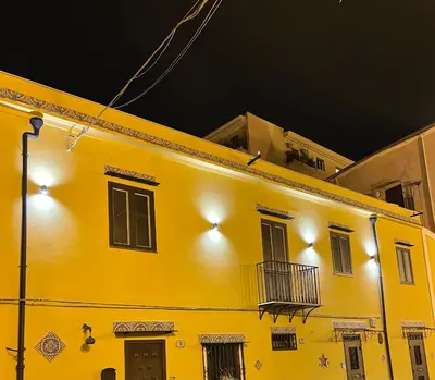 a yellow building with lights on it at night at Case vacanze donna Ina in Palermo